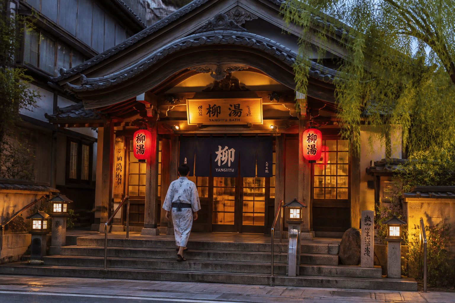 Façade en bois traditionnelle d'un sotoyu, bain public de Kinosaki Onsen, à la tombée du jour